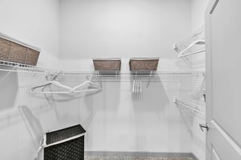 A clean, empty kitchen with white cabinets and a white refrigerator.